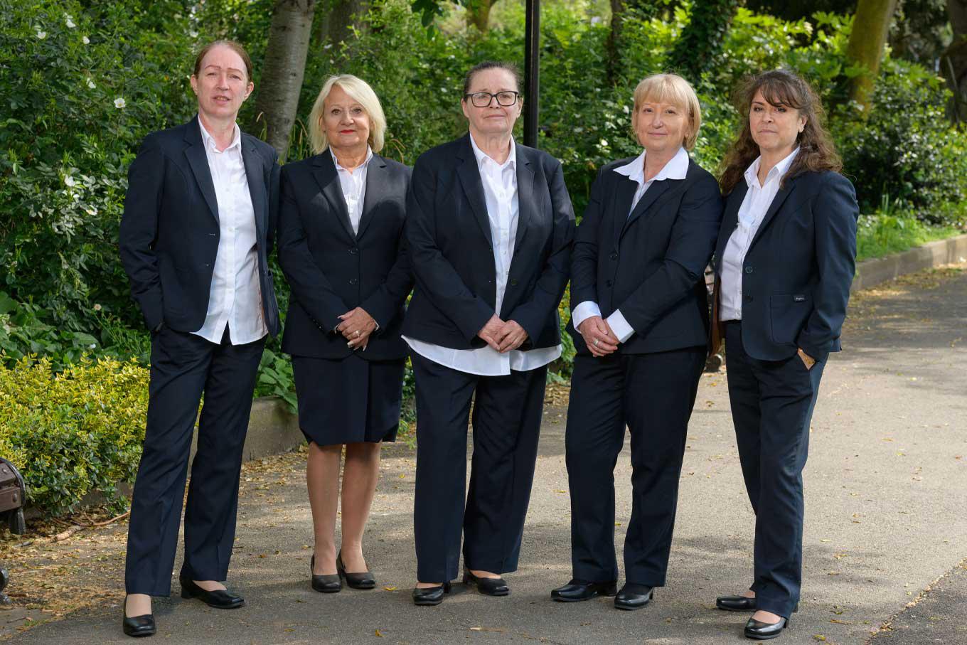 Funeral arrangers and members of the team from JH Kenyon funeral directors in Hampstead stand together in a local park.
